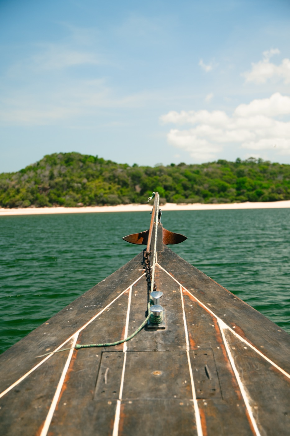 Proa de barco de madeira navegando em rio da Amazônia